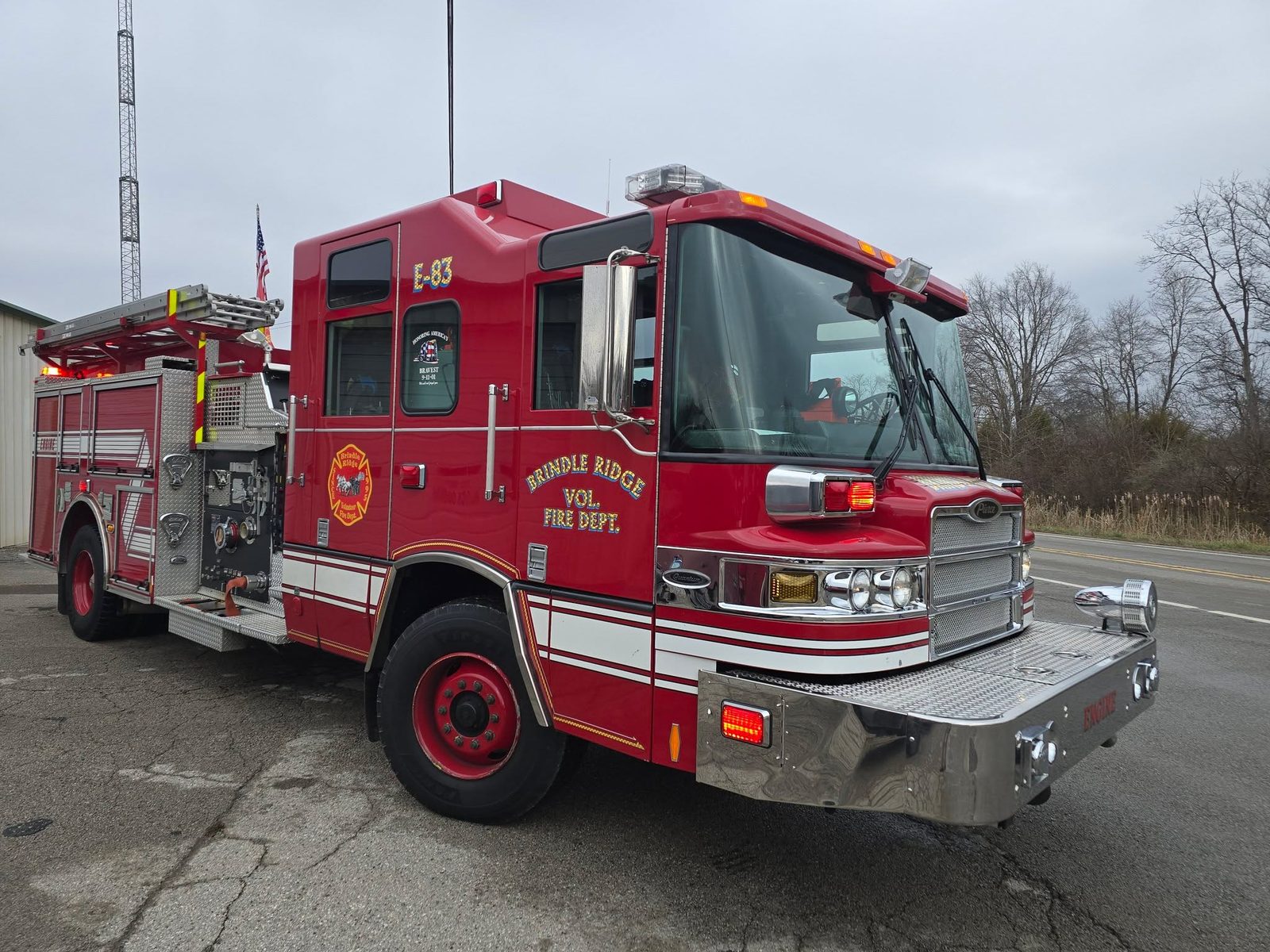 Engine 83, a red Pierce Quantum rescue engine parked outside the station